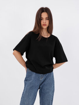 mockup of a black loose-fitting t-shirt on a young beautiful girl