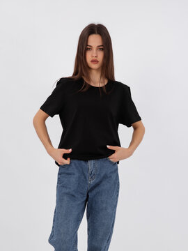 mockup of a black loose-fitting t-shirt on a young beautiful girl