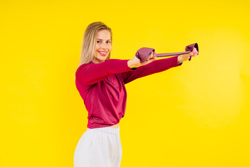 Fototapeta na wymiar Sports woman in fashion sportswear exercising with elastic band in studio
