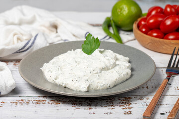 Haydari mezze. Traditional Asian flavors. A fresh snack with yoghurt and mint. Haydari appetizer on white wood background