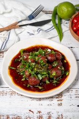 Aleppo meatballs. Traditional Asian flavors. Meatballs with tomato paste. Aleppo meatballs on white wood background