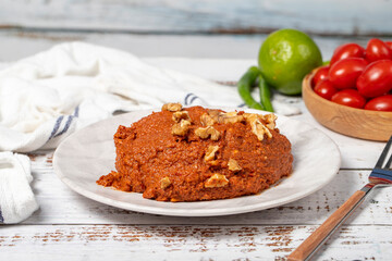 Muhammara appetizer. Traditional Asian flavors. Snack prepared for breakfast. Muhammara on white wood background. Close up