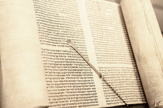 Jewish rabbi read the Torah scroll with his Torah reading hand.
