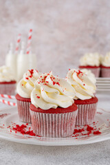 Red velvet cupcakes with cream cheese frosting and red sugar hearts. Delicious dessert for Valentines day. Selective focus, copy space.