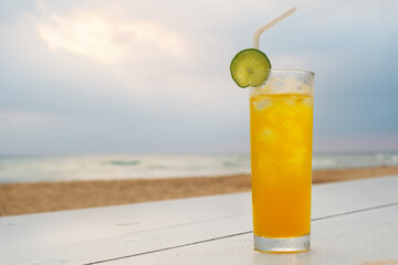 Glass of fruit cocktail decorated lime slice. Beach bar.