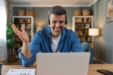 Business man with headsets working on laptop at home office. Customer service assistant working in...