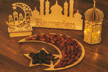 Ramadan Kareem. Dates on wooden tray in the shape of a month and a star and oriental wooden Lantern...