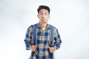 funny young Asian student man 20s wearing casual clothes with backpack posing confidently and looking at camera isolated on white background. Education in high school university college concept