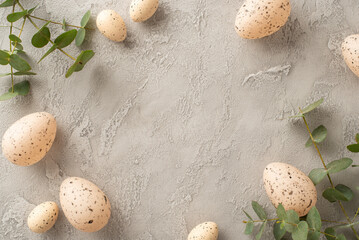 Modern, eco-centric Easter setup. Top view of pastel eggs, and eucalyptus on a grey concrete...