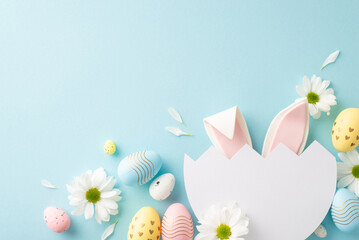 Whimsical Easter imagination concept. Top view of cute bunny ears visible through split egg, with...