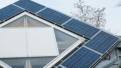 Fototapeta premium Rooftop solar panels on home in Germany. Unusual shape of the roof. Green renewable energy theme. Aerial.
