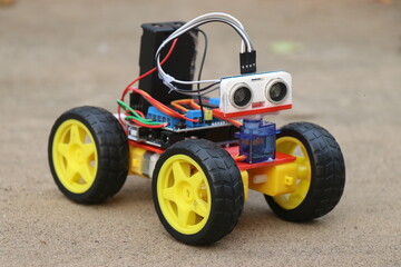 Fototapeta premium Programmable robotic car built using micro controller and ultrasonic distance sensor along with servos and dc motor. Working prototype of a car