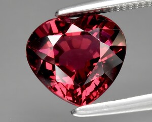 natural red pink garnet rhodolite gem on the background