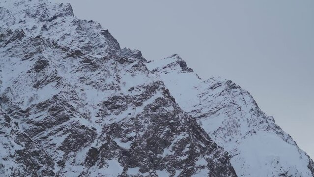 Stormy clouds above the snowy mountain peak of the Himalayan mountain range at Jispa in Lahaul, Himachal Pradesh, India. Winter storm clouds covers the snowy mountain peaks during the bad weather.