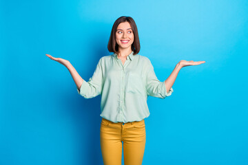 Photo of adorable cute woman with bob hairstyle dressed turquoise shirt palms hold objects empty...