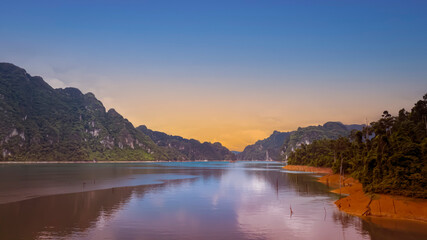 Sunset scene in Khao Sok national park Cheow Lan Dam lake with blue sky background in Surat Thani, Thailand