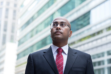 Fototapeta premium Confident Indian Business man standing in modern city