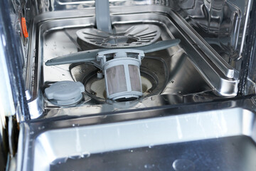 Broken dishwasher in the kitchen, close-up photo.
