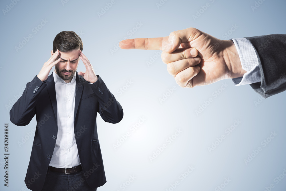 Poster abstract image of boss hand pointing at stressed businessman on light gray background. bad job decis