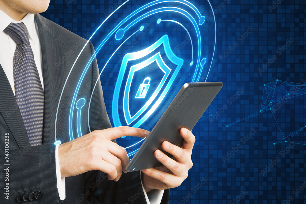 Poster close up of businessman hand using tablet with glowing padlock shield hologram on blurry blue backgr