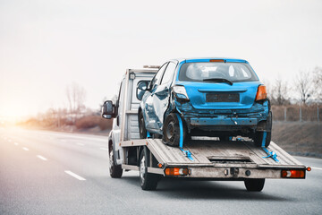 Fototapeta na wymiar Towing Truck With A Damaged Vehicle After Car Accident Collision