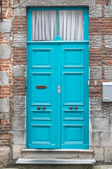 blue wooden door against the background of a gray brick wall, rustic doors