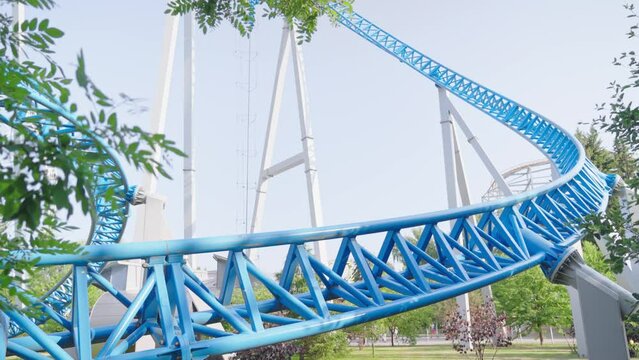 Roller coaster Ride against blue sky. Roller coaster in the amusement park. Cheerful entertainments in park of attractions