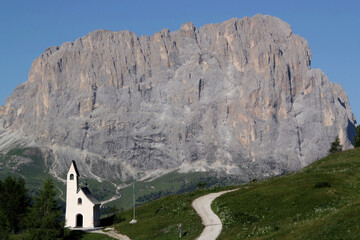 Photo with a view of the Cappella di San Maurizio church against the backdrop of the Sassolungo...