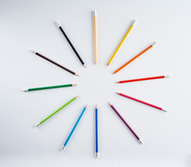 Many rainbow colored pencils on white