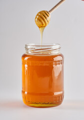Golden bee honey jar on white