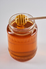 Golden bee honey jar on white