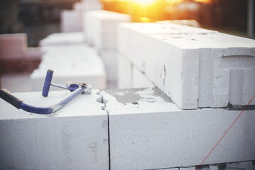 Masonry white blocks with saw close up. Milling cutter on autoclaved aerated concrete blocks in...