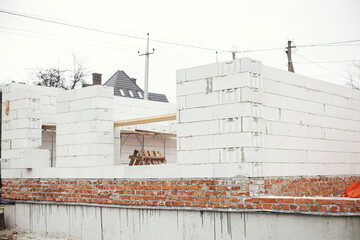 Masonry autoclaved aerated concrete blocks and bricks on concrete foundation. Laying walls with...