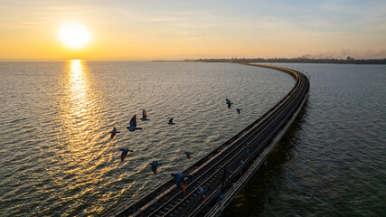 Sunset view with railway tracks above dam water in Lop Buri Province, Thailand. - obrazy, fototapety, plakaty