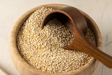 Dry quinoa uncooked in a wooden bowl. Healthy eating