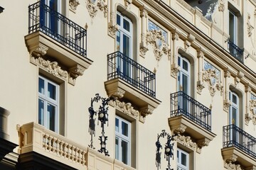 Fototapeta na wymiar Windows and balconies on baroque antique facade with elegant deco details in Madrid, Spain