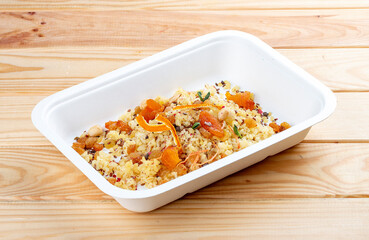 Bulgur on coconut milk. Healthy food. Takeaway food.  On a wooden background.