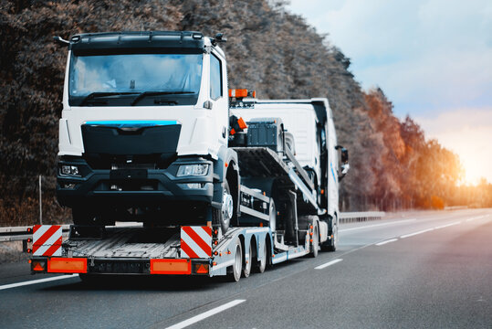 Towing truck with a brand-new commercial vehicle for cargo shipping. Emergency roadside assistance. Vehicle Mechanical Problem on the Road. Warranty case. Bill of Loading Manifest.	