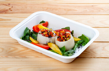 Squid stuffed with vegetables. Healthy diet. Takeaway food.  On a wooden background.