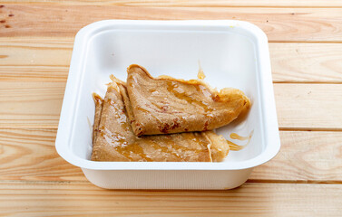 Buckwheat pancakes with farmer's honey. Healthy diet. Takeaway food.  On a wooden background.