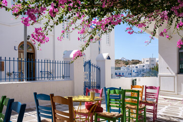 View of a bar restaurant with a picturesque terrace outdoors and colorful chairs in Ios cyclades...