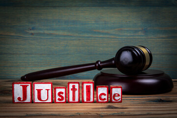 JUSTICE. Red alphabet letters and judge's gavel on wooden background. laws and justice concept