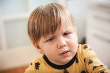 Close up of beautiful angry baby, looking sad showing disappointment. Sad child portrait