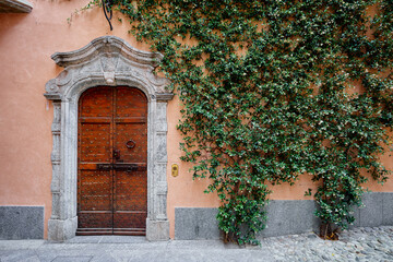 Ancient stone wall of old building with wooden vintage door.