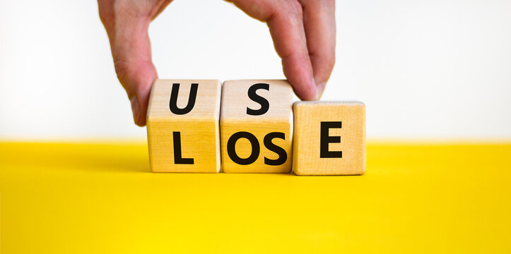 You use or lose it symbol. Concept word Use or lose on wooden cubes. Beautiful yellow table white background. Businessman hand. Business and you use or lose it concept. Copy space.