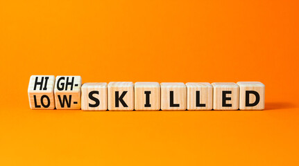 High or low skilled symbol. Concept words High-skilled or Low-skilled on beautiful wooden blocks. Beautiful orange table orange background. Business high or low skilled concept. Copy space.