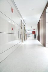 Bright and sterile hospital corridor with visible emergency signage.