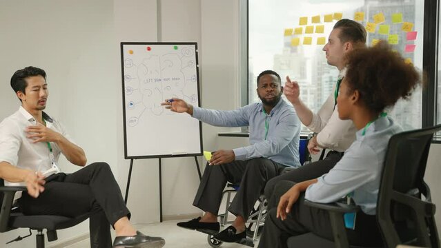 handicapped African businessman explaining plans during team meeting with colleagues in the company, concept of equality,  business

