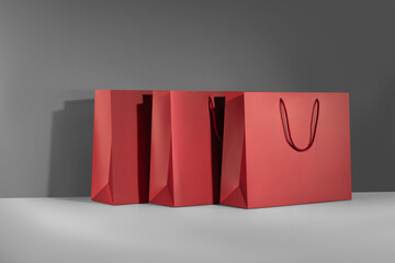 Red paper glossy shopping bag mockup with red handles.