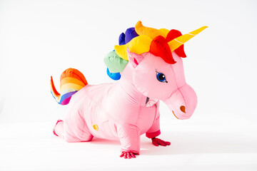 Pink unicorn inflatable costume kneeling on floor